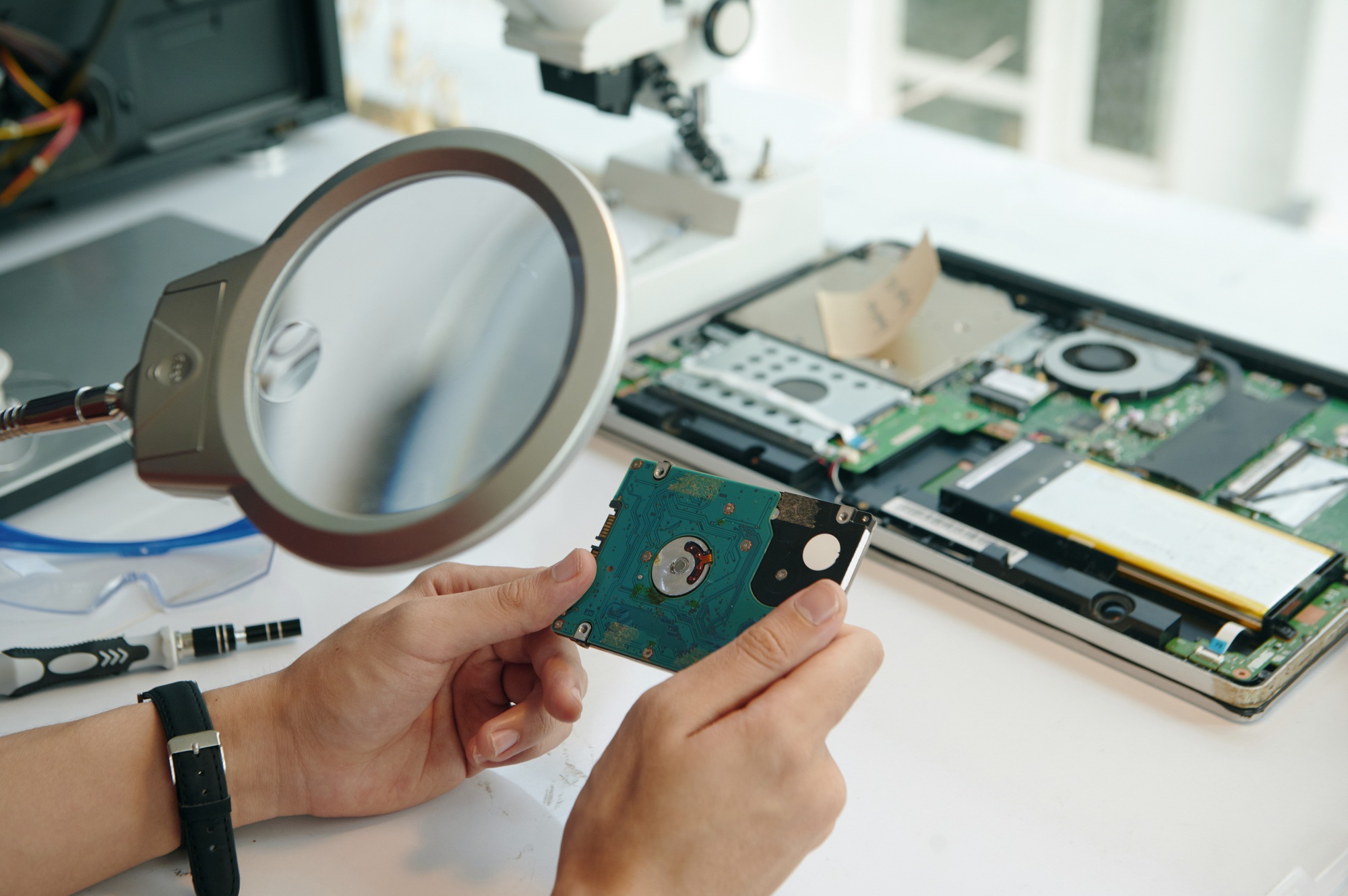 Repairman Looking At Disk Through Magnifier